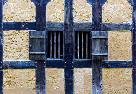 Wooden shutters in the wall of an old adobe houseの写真素材