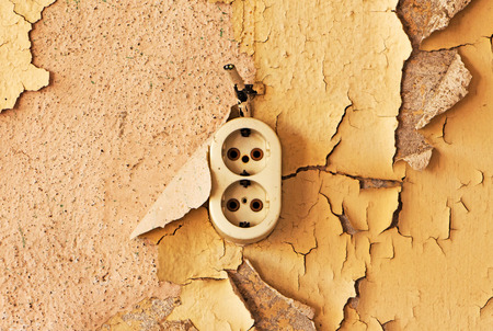Old electrical outlet and cable on a decrepit wallの写真素材