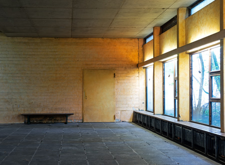 Old abandoned room with a bench and a doorの写真素材