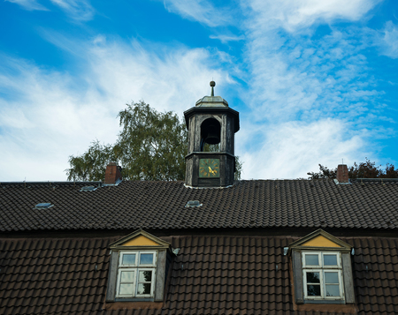 Bell tower with chimes on the roof of the old houseの写真素材