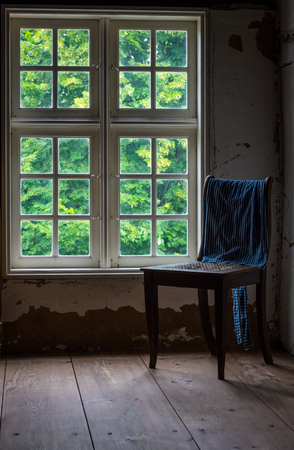 The old and wooden chair in a room.の写真素材