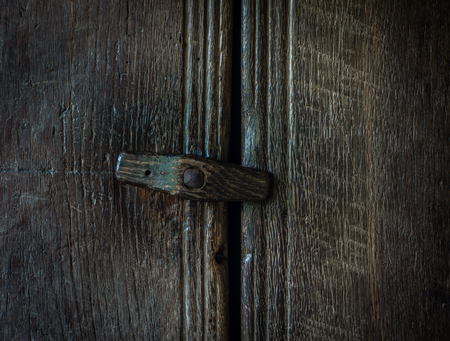 The wooden latch on a wooden door.