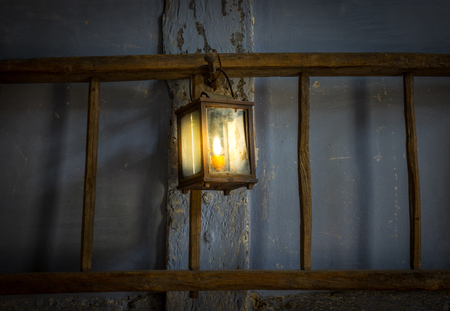 The old kerosene lamp on a wall in dark room.の写真素材