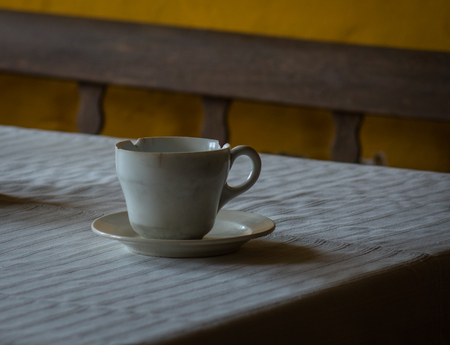 The old and vintage cup on a wooden table.の写真素材