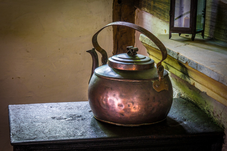 The old and ancient kettle on a stove.の写真素材