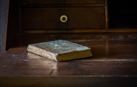 The old and vintage book on a wooden table.