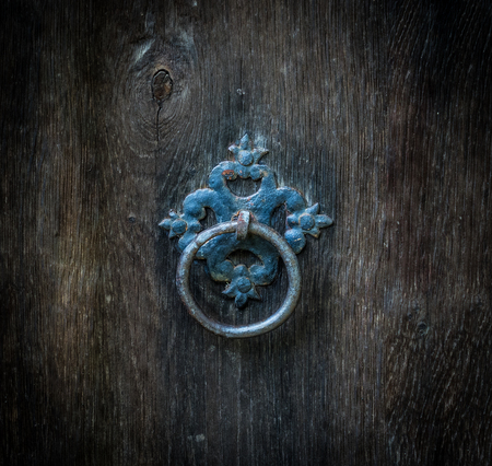 The Old rusty ring on a wooden door.