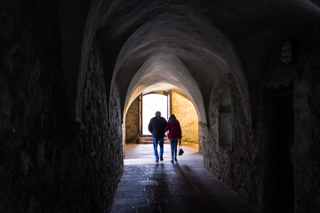 Dark stone street  in an old town  and people.の写真素材