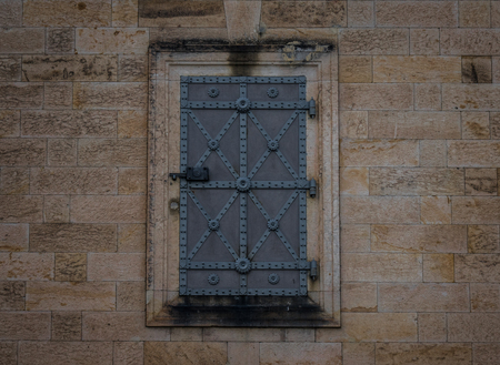 The iron door in a stone wall.の写真素材