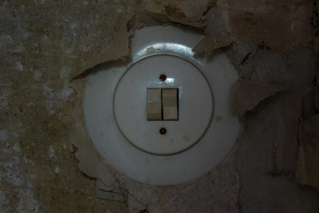 Old electrical switch on a decrepit wall, lost places.の写真素材
