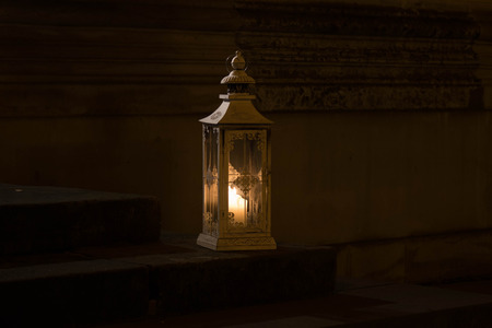 The old lantern with candle on stone step of stairs.