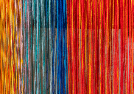 Colored threads of an ancient wooden loom .の写真素材