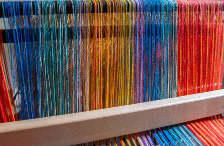 Colored threads of an ancient wooden loom .の写真素材
