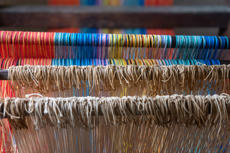 Colored threads of an ancient wooden loom .の写真素材