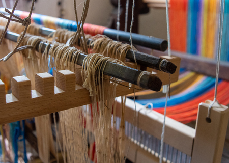 Colored threads of an ancient wooden loom .の写真素材