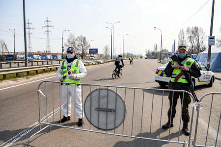 Policemen and national guards is stand at a checkpoint during disease COVID-19 outbreak in Kyiv,...