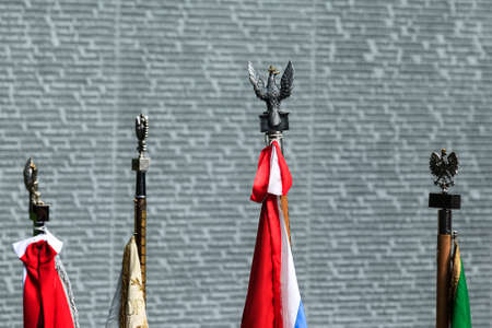 State flags of Poland near Memorial wall with the names of Poles, victims of Stalinist repressions at the Polish military cemetery Polish graves in Bykivnia near Kyiv. Ukraine. September 2012のeditorial素材