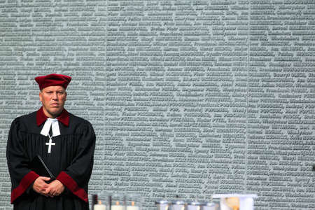 Catholic priests near Memorial wall with the names of Poles, victims of Stalinist repressions at the...