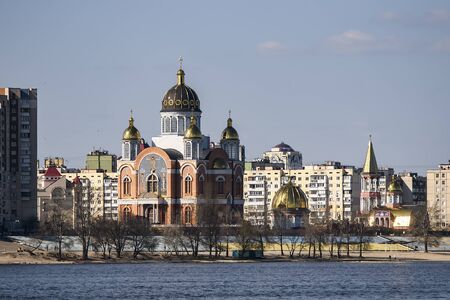 View to St. Pokrovskiy Cathedral Intercession and apartment buildings on Obolon embankment in Kyiv,...