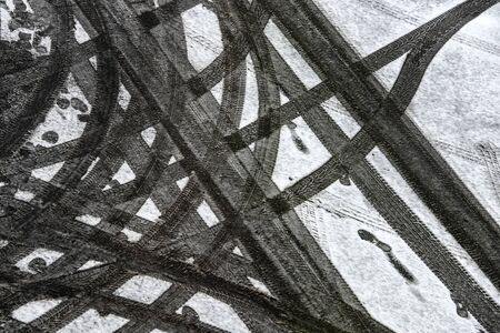 Traces of car tire treads on snow-covered asphalt. Ukraine.