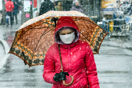 Woman wearing protective mask as a preventive measure against the coronavirus COVID 19 on street in Kyiv, Ukraine.のeditorial素材