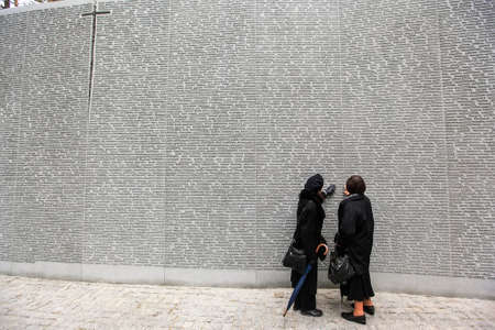 People read names of Poles, victims of Stalinist repressions, on Memorial wall at the Polish military cemetery Polish graves in Bykivnia near Kyiv. Ukraine. September 2012のeditorial素材
