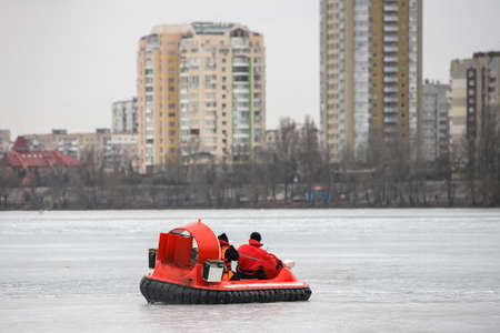 Ukrainian rescuers of the State Emergency Service cross a frozen river on an aeroglisser in Kyiv, Ukraine. March 2021のeditorial素材