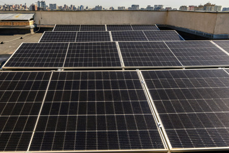 Solar panels installed on the rooftop of a residential building, with a skyline of modern...