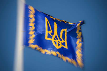 The official standard of the President of Ukraine waves against the blue sky in Kyiv, Ukraine,...