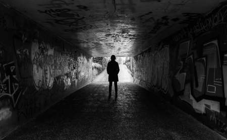 Young woman standing in a concrete tunnelのeditorial素材