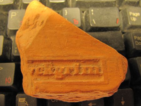 Fragment of archaeological stone with inscription, lying on a keyboard.の写真素材