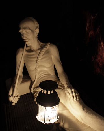 The statue of old man sitting and smoking opiumのeditorial素材
