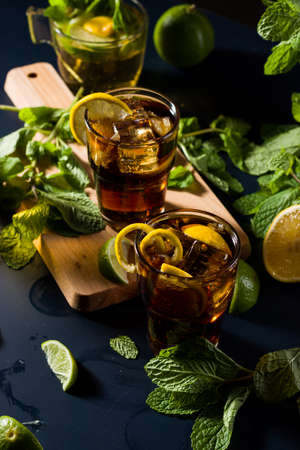 Glasses of cool refreshment coke with organic lemon slices and ice cubes served on a gold tray.の写真素材