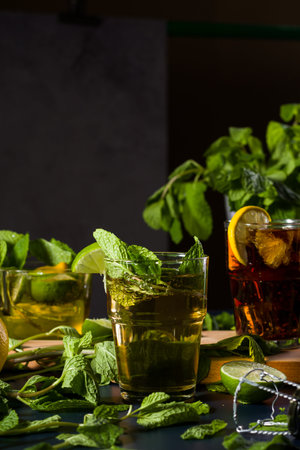 Glasses of cool refreshment coke with organic lemon slices and ice cubes served on a gold tray.
