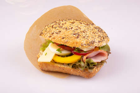 Ciabatta with vegetables, egg, ham, cheese on a white backgroundの写真素材