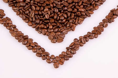 Part of the heart made of roasted coffee beans. On a light background.の写真素材