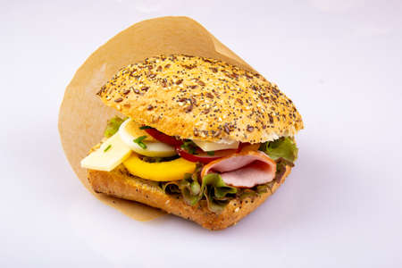 Ciabatta with vegetables, egg, ham, cheese on a white backgroundの写真素材
