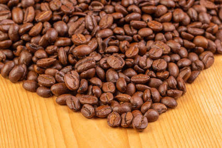 Closeup of roasted coffee beans lying on a wooden background. Macro.の写真素材