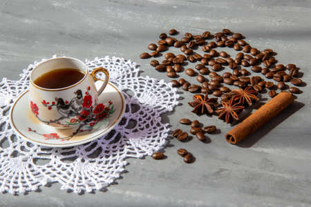 A cup of coffee with coffee beans and cinnamon and aniseの写真素材