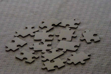 Blank puzzle pieces on a gray cloth. Randomly set on table without any markings or pictures.の写真素材
