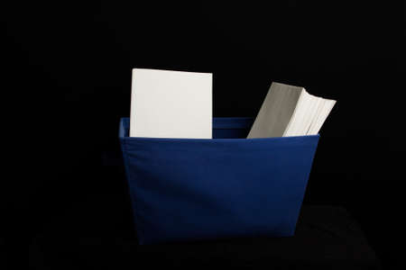 Blue ballot carrier with blank white envelopes on a black background. Some envelopes facing forward some facing sideways. Carrier is blue cloth with base fading to shadow.の写真素材