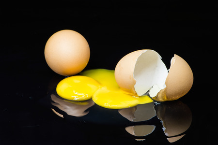broken egg on a black の写真素材