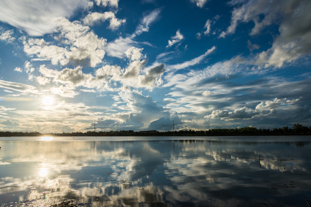 Sun and Blue sky with clouds over the reservoirの写真素材