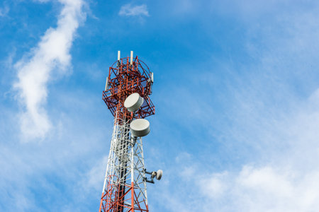 telecommunications tower with many satellite dish on blue sky cloud background.