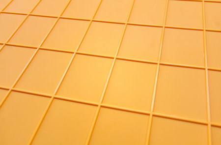 yellow plastic surface with embossed grid pattern abstract texture, ribbed or reinforced plastic background backdrop or wallpaper for graphic designの写真素材