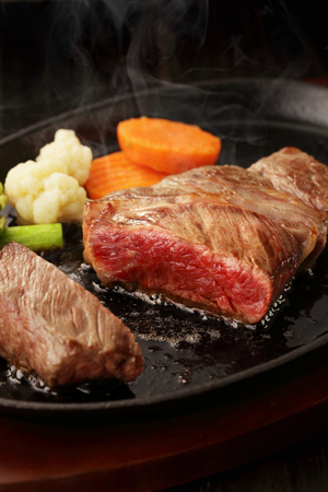 Beef steak on steel plateの写真素材