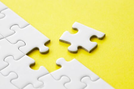 White jigsaw puzzle on yellowの写真素材