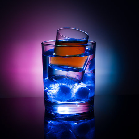 A shot glass with liquor and iceの写真素材