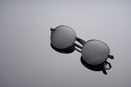 Sunglasses using soft focus on black glass surfaceの写真素材
