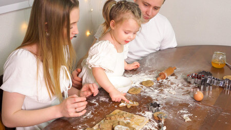 Happy family having fun with flour while cooking cookies.
